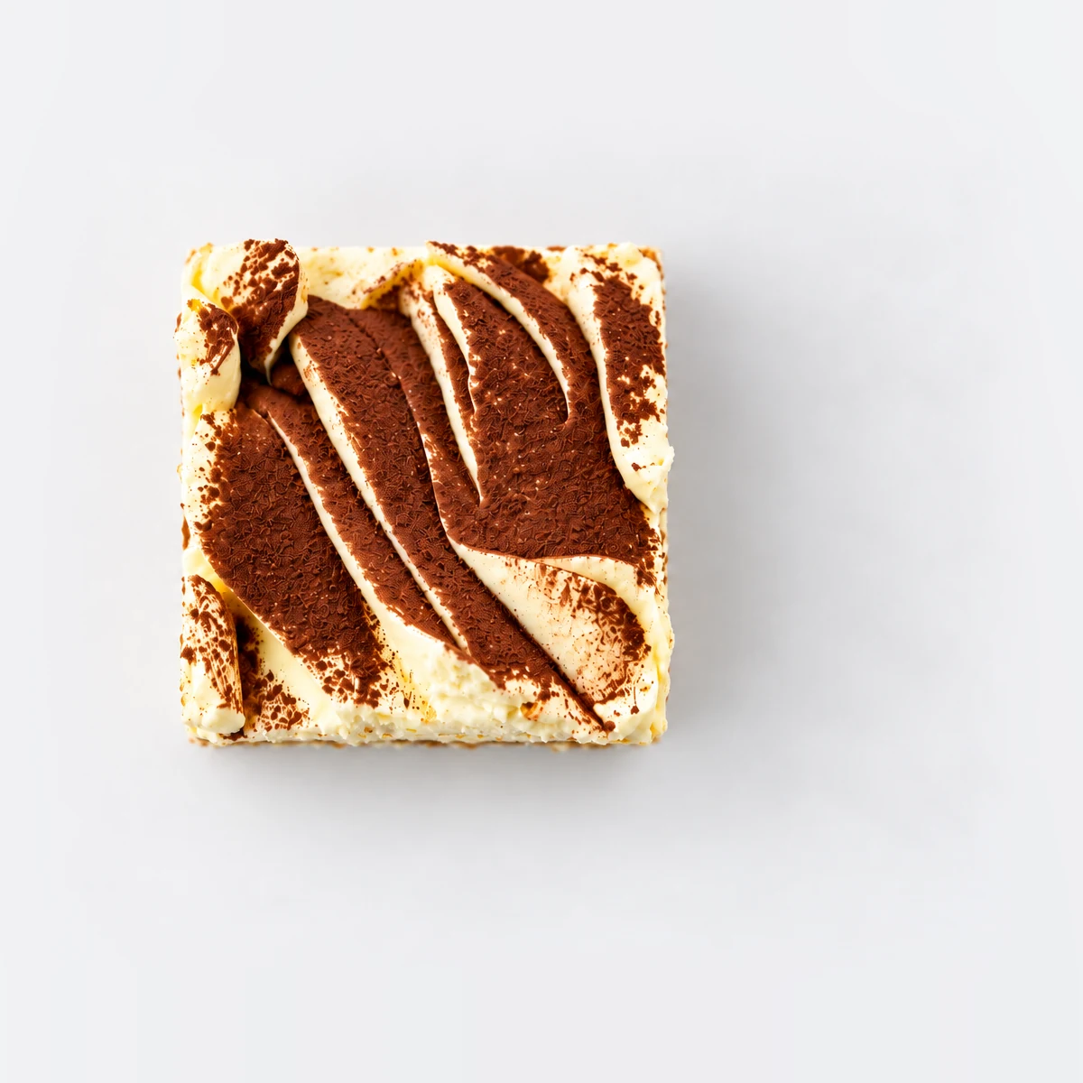 Tiramisu cake slice from above, with cocoa dusted over the cream.