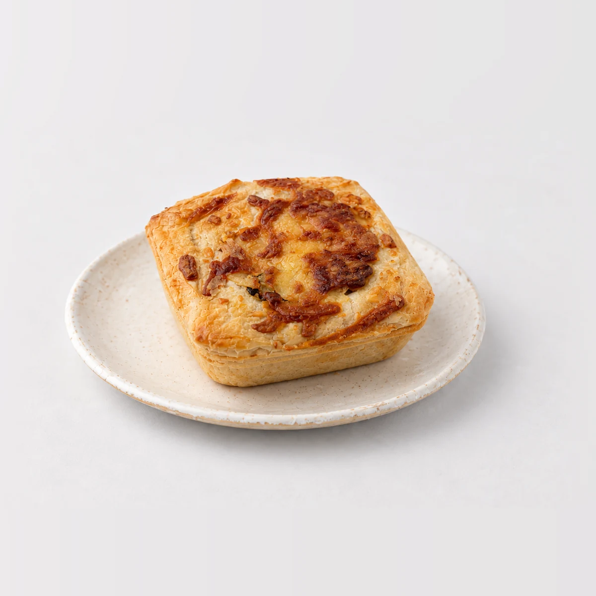 Steak Cheese and Bacon Pie, whole on a plate