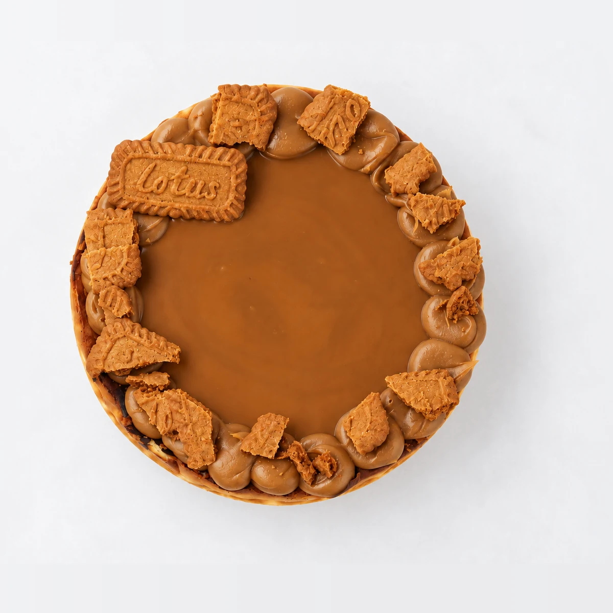 Baked Biscoff cheesecake from above: a smooth Biscoff caramel centre ringed with rosettes and Lotus biscuit pieces.