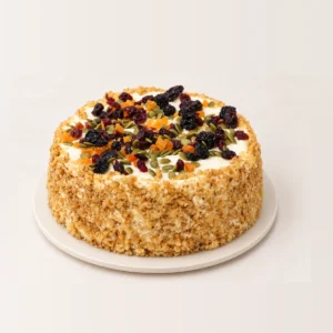 Close-up of the carrot cake's cream cheese frosting scattered with dried cranberries, apricot and pumpkin seeds.