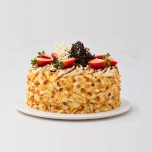 Side view of the continental cake showing toasted flaked almonds pressed around the sides.