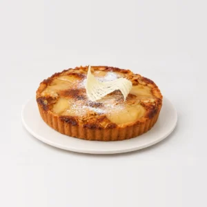 Side view of the frangipane tart showing its fluted shortcrust edge and golden baked top.