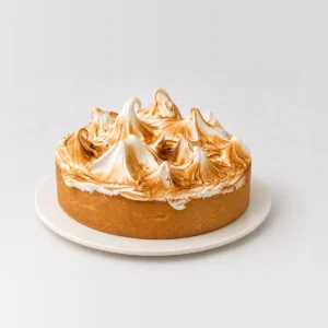 Side view of the lemon meringue tart with caramelised meringue peaks above the pastry case.