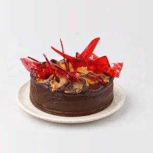 Toffee Mars cake with a chocolate glaze, caramel on top and tall red toffee shards.
