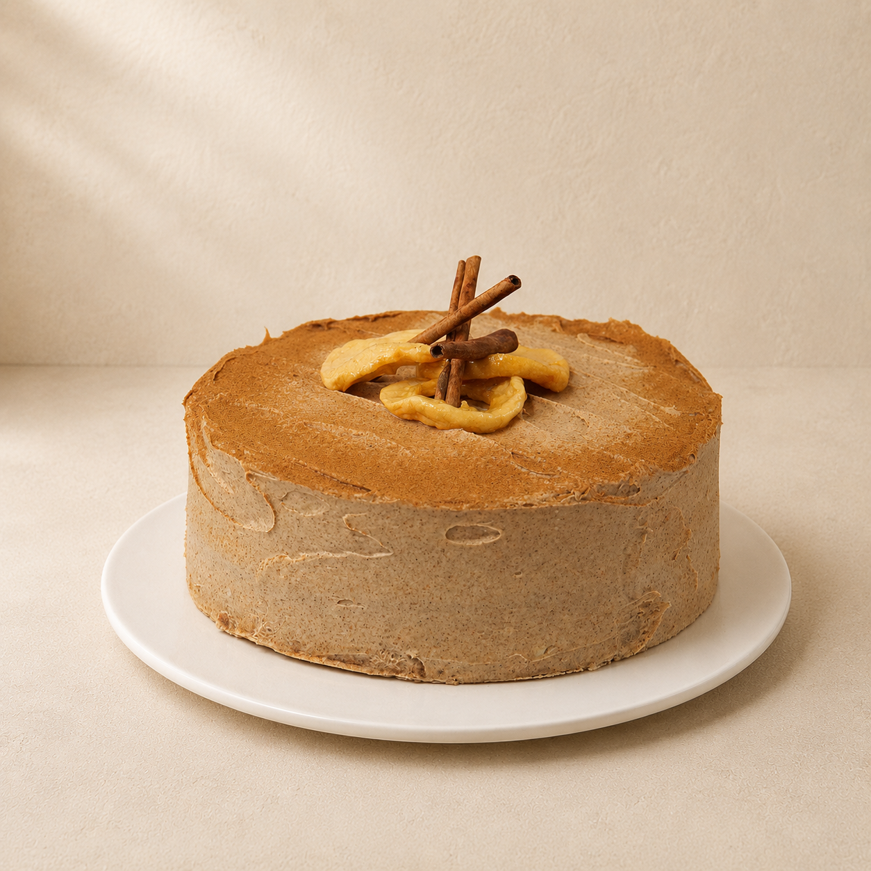 Apple and cinnamon tea cake with smooth cinnamon frosting, topped with cinnamon sticks and apple.