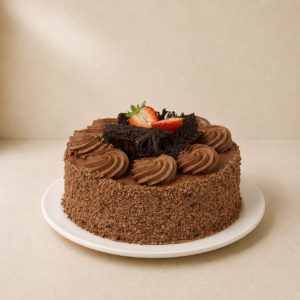 Chocolate mousse sponge cake with mousse rosettes, chocolate-crumb sides and a strawberry.