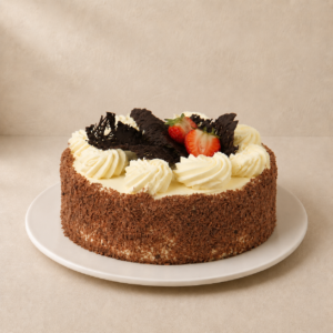 Chocolate sponge cake with chocolate-shaving sides, cream rosettes, chocolate shards and a strawberry.