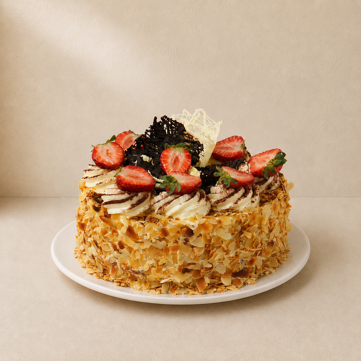 Continental cake coated in toasted flaked almonds and topped with cream, chocolate shards and strawberries.