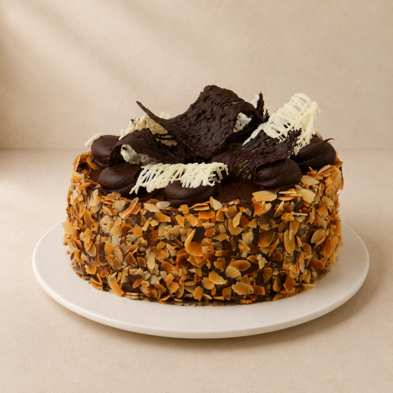 Flourless Jamaican chocolate cake coated in flaked almonds and topped with chocolate ganache and shards.