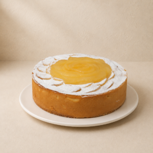 Lemon, lime and pear tart with a smooth pale citrus filling and an icing-sugar-dusted edge.