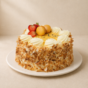 Passionfruit sponge cake with toasted coconut sides, cream rosettes and fresh passionfruit.