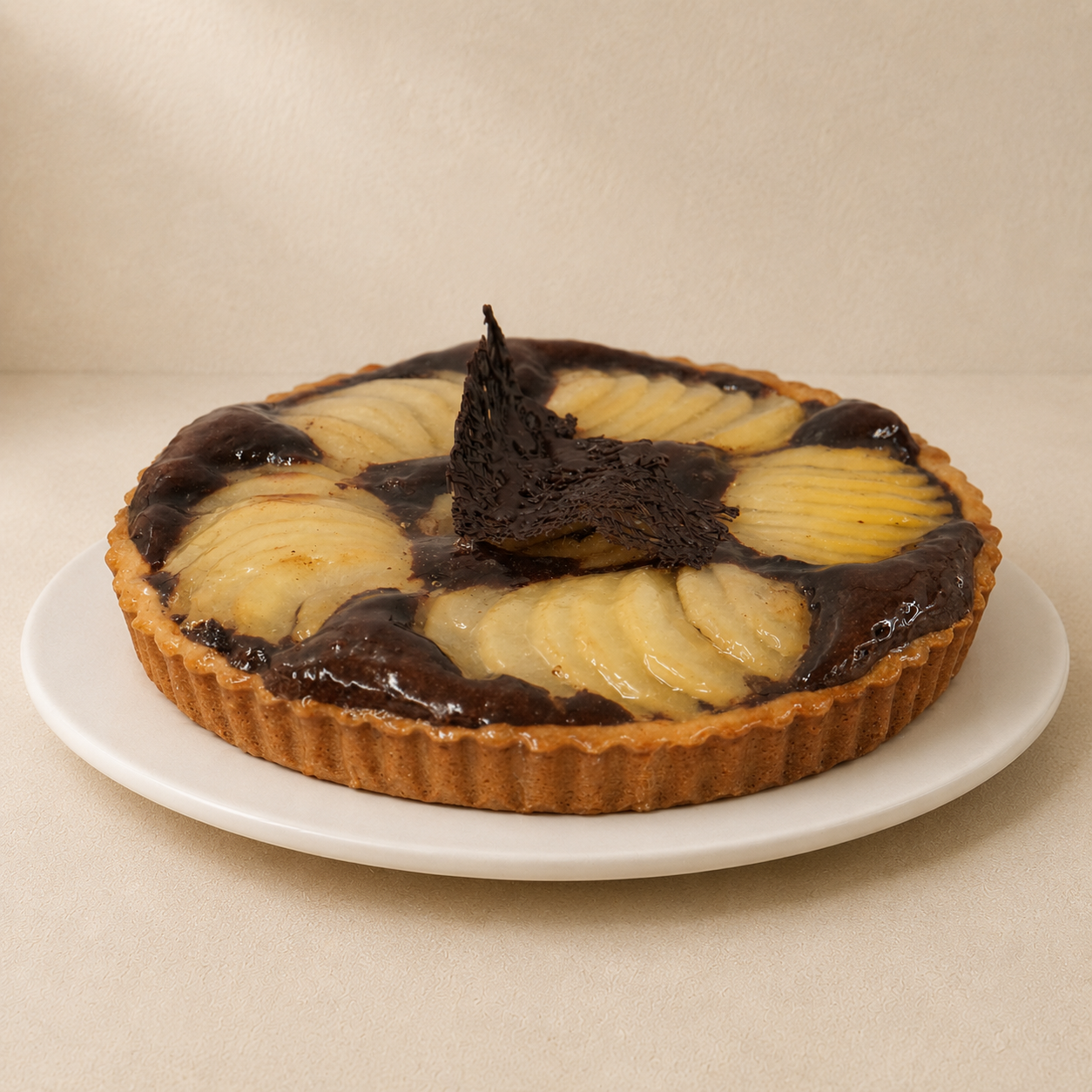 Pear and chocolate tart with poached pear slices arranged over a chocolate filling.