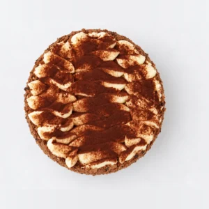 Tiramisu cake from above: swirls of cream dusted with cocoa powder.