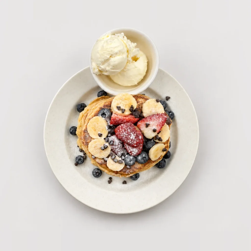 Tall pancake stack with fruit and ice cream — Top-down