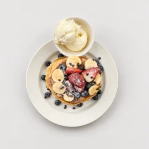 Tall pancake stack with fruit and ice cream — Top-down