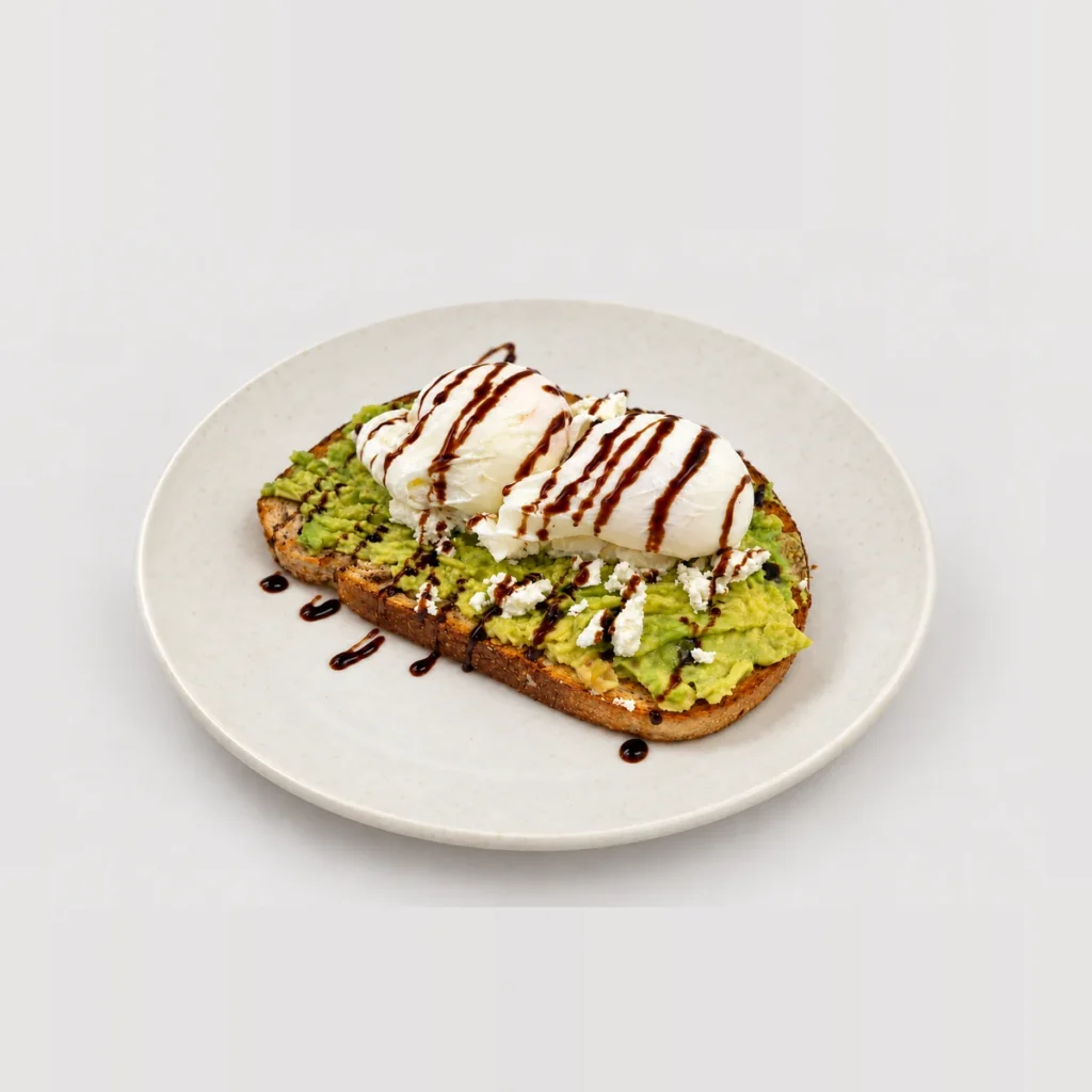 Avocado feta toast, poached eggs, dark drizzle — Whole / angled