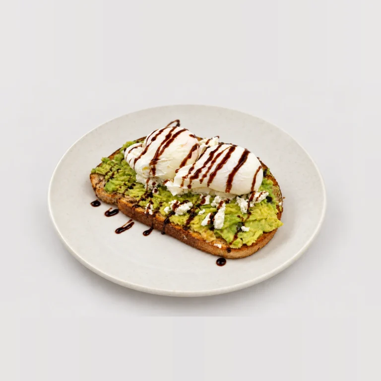 Avocado feta toast, poached eggs, dark drizzle — Whole / angled