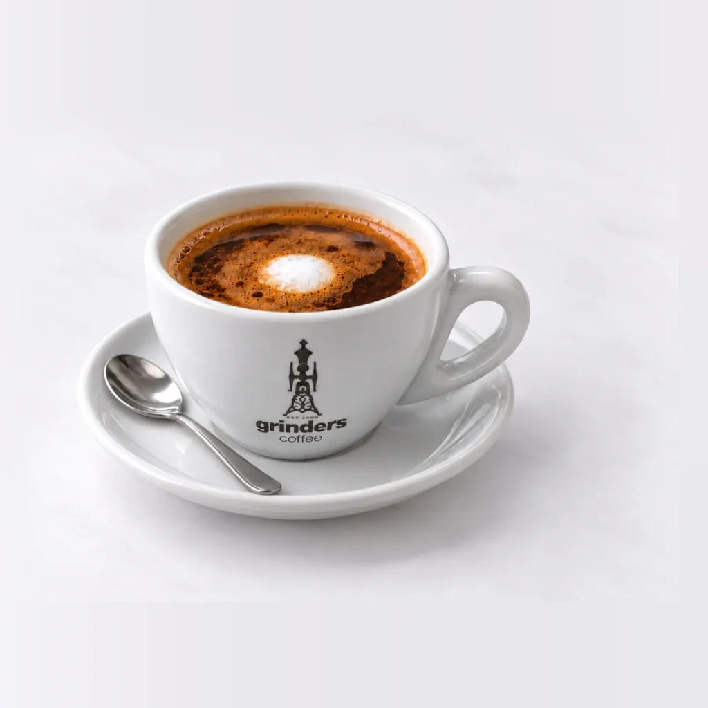 Long Macchiato in the smaller Grinders cup on white background